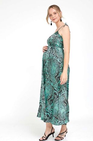 אישה לובשת שמלת הילה להריון ירוק מודפס של אבישג ארבל