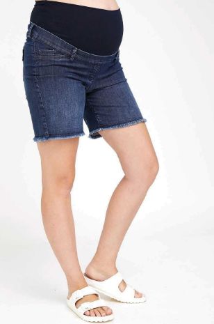 אישה לובשת ג'ינס להריון קרעים קצר כחול כהה של אבישג ארבל