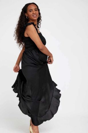 אישה לובשת שמלה שחורה של אבישג ארבל	