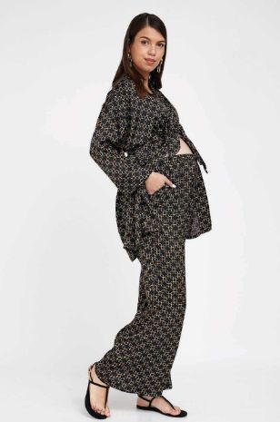 אישה לובשת קימונו סאטן להריון שחור מודפס של אבישג ארבל