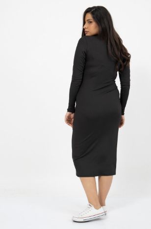 אישה לובשת שמלת ריב להריון צווארון פולו שחור של אבישג ארבל