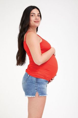 אישה לובשת גופיית ספגטי להריון אדום בהיר