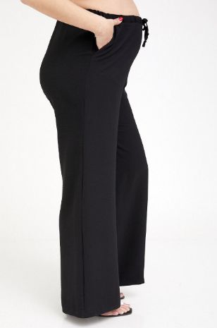 אישה לובשת מכנסי הרפר הריון שחורים