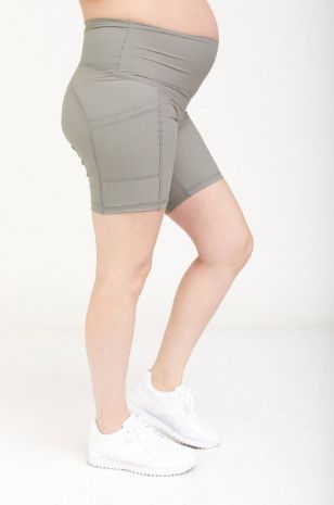 אישה לובשת טייץ הריון אקטיב קצר חאקי של אבישג ארבל