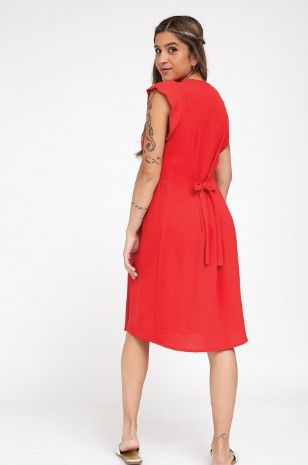 אישה לובשת שמלת הריון אורין אדומה של אבישג ארבל