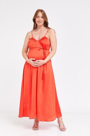 אישה לובשת שמלת הילה להריון אדומה של אבישג ארבל