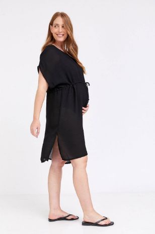 אישה לובשת שמלת חוף להריון אואזיס שחורה של אבישג ארבל