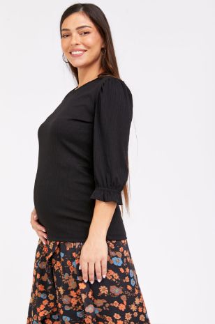 אישה לובשת חולצת הריון אודט שחורה של אבישג ארבל