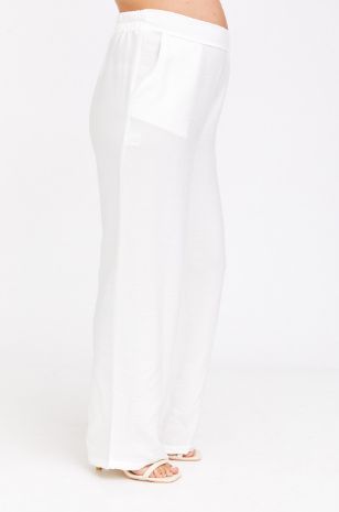 אישה לובשת מכנסי סימון לבן של אבישג ארבל