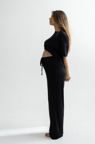 אישה לובשת מכנסי הריון ריבה שחורים של אבישג ארבל	