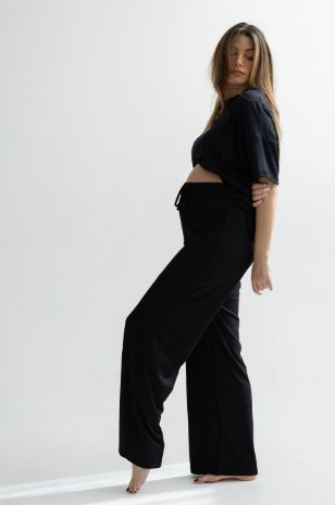 אישה לובשת מכנסי הריון ריבה שחורים של אבישג ארבל	