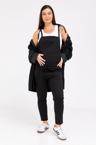 אישה לובשת אוברול הריון רוני ארוך שחור של אבישג ארבל