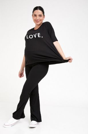 אישה לובשת טי שירט הריון LOVE שחור ושמנת של אבישג ארבל