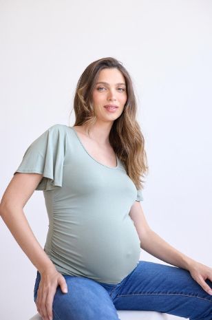 אישה לובשת 	חולצת הריון בילי זית בהיר