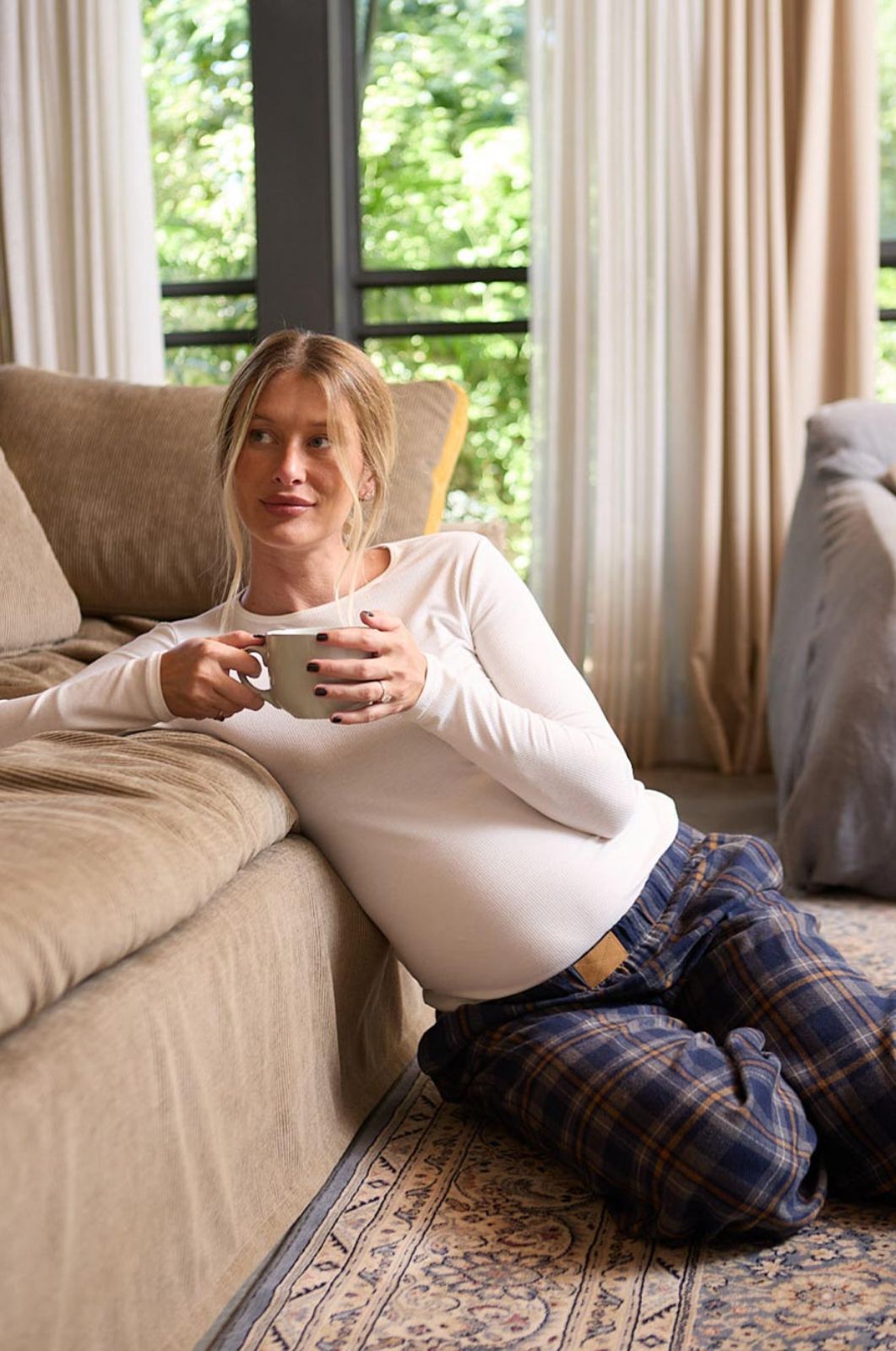 אישה לובשת חולצת הריון צמודה שמנת