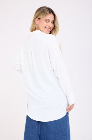 אישה לובשת חולצת הריון מכופתרת פרינסס לבנה