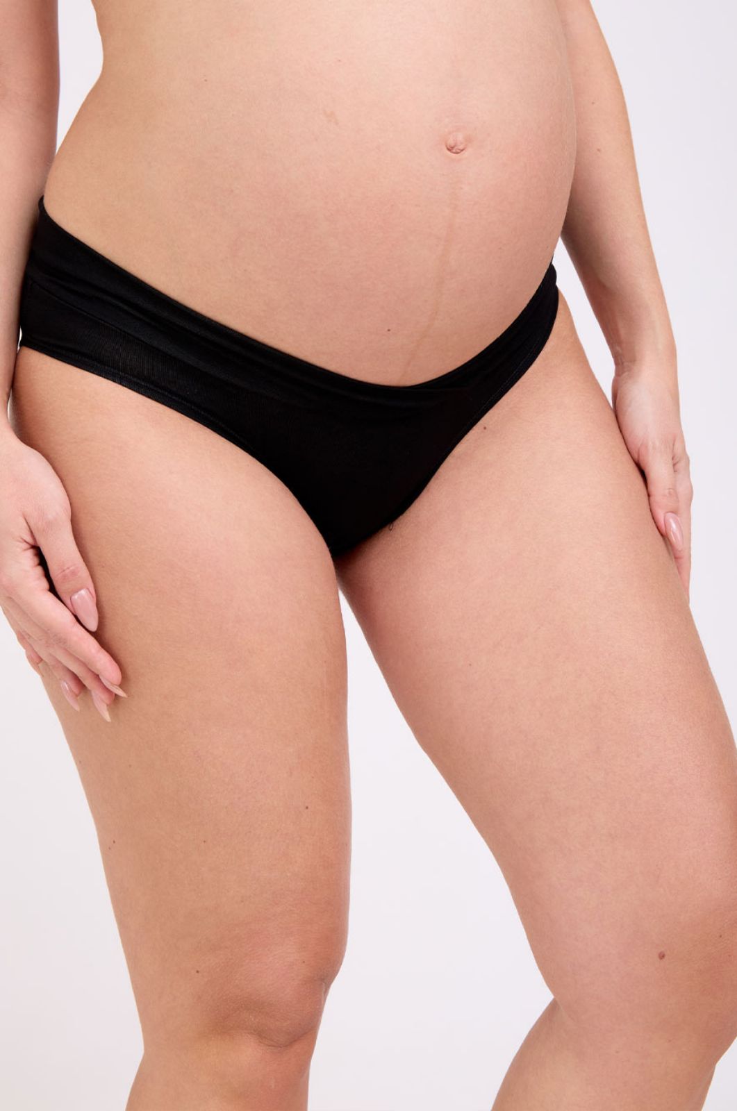 אישה לובשת תחתוני מעטפת להריון שחור של אבישג ארבל