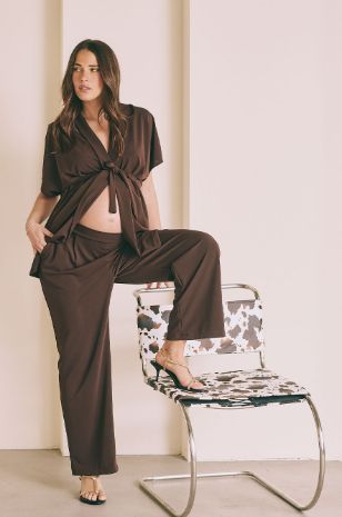 אישה לובשת מכנסיים להריון מחוייטים חום