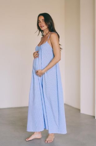 אישה לובשת שמלת הריון קיצית פסים תכלת לבן 