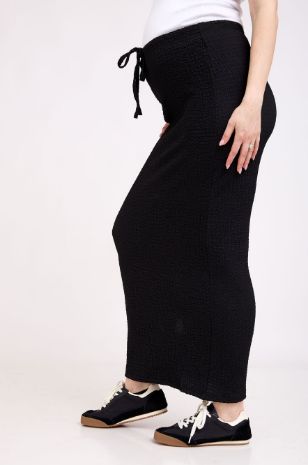 אישה לובשת חצאית הריון צנועה שחורה