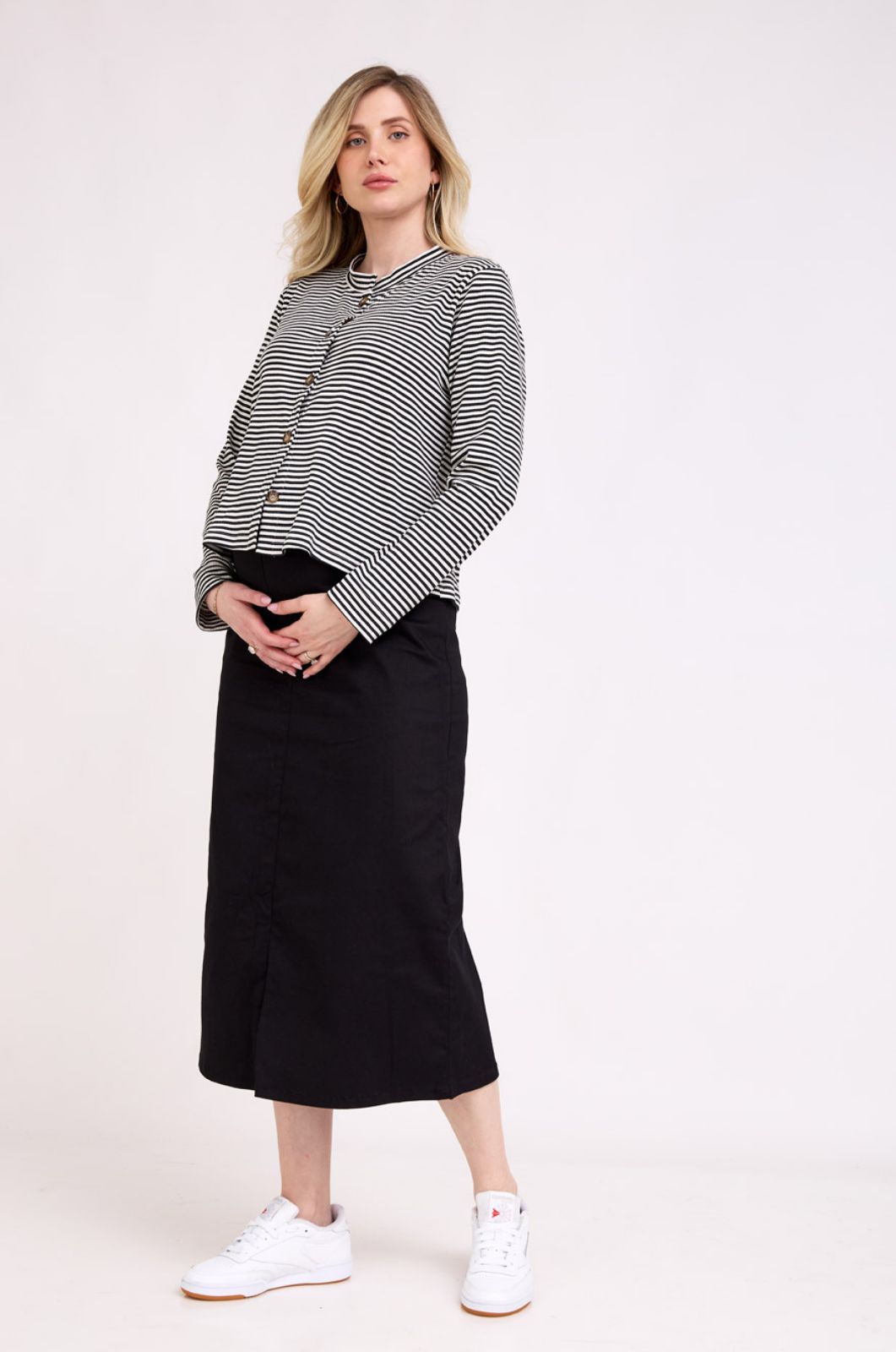 אישה לובשת חצאית הריון קורל שחורה של אבישג ארבל