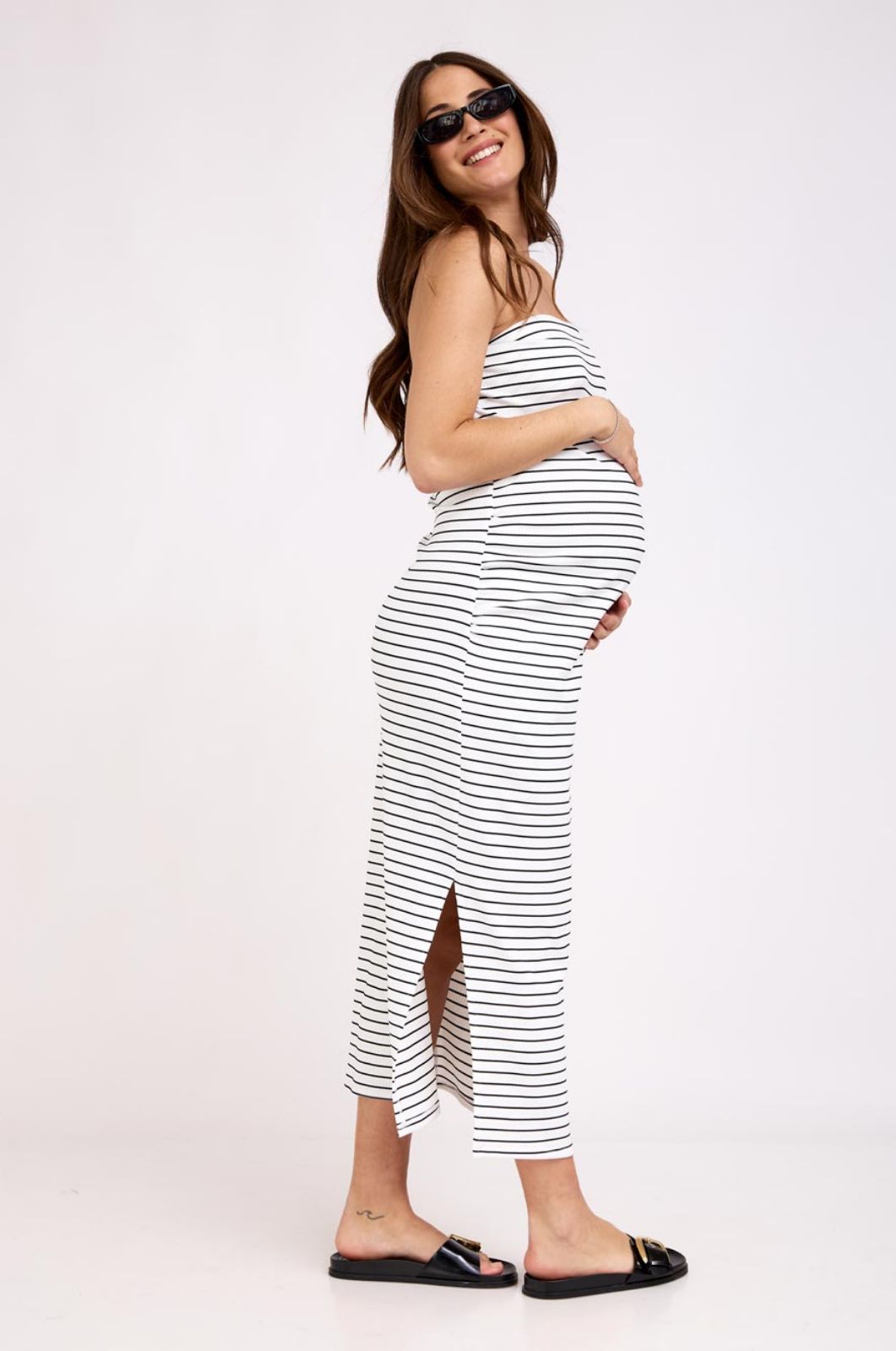 אישה לובשת שמלת סטרפלס להריון פסים שמנת פס שחור של אבישג ארבל