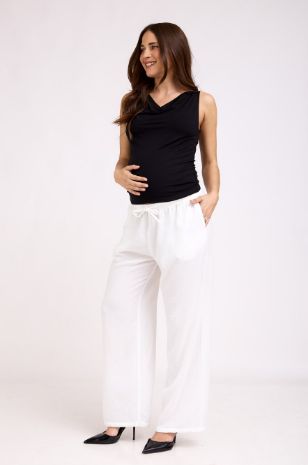 שלמור שטרוזמן לובשת מכנסי הריון תמוז לבנים של אבישג ארבל