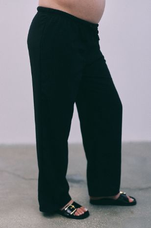 אישה לובשת מכנסי הריון תמוז שחורים של אבישג ארבל