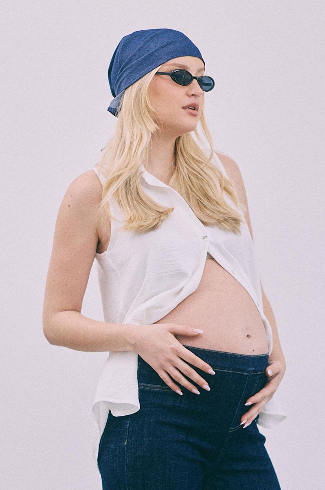 אישה לובשת חולצה גברית ללא שרוול לבנה של אבישג ארבל